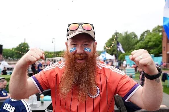 Hombre con camiseta escocesa celebrando en evento