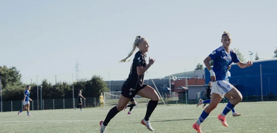Jugadoras compitiendo en partido de fútbol