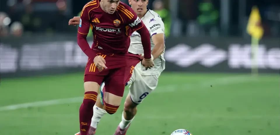 Jugador de Roma avanzando mientras es seguido por rival