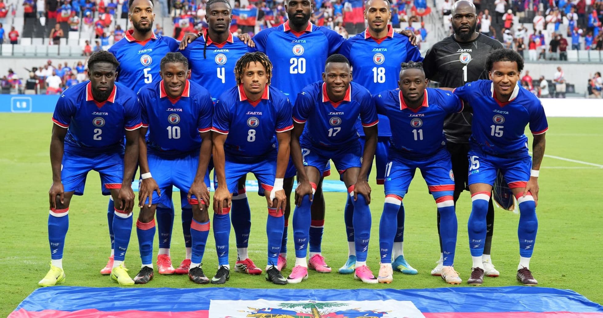 Equipo de Haití posando con bandera nacional