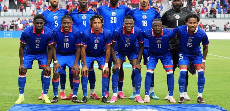Equipo de Haití posando con bandera nacional