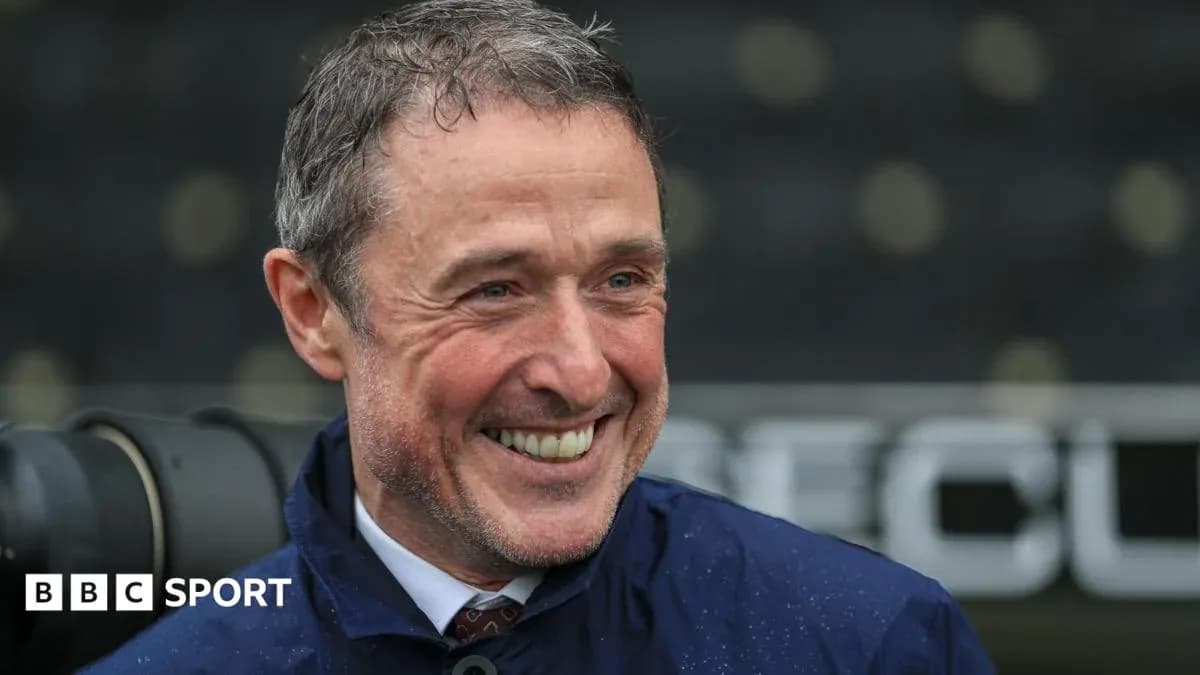 Entrenador sonriendo en el campo de fútbol