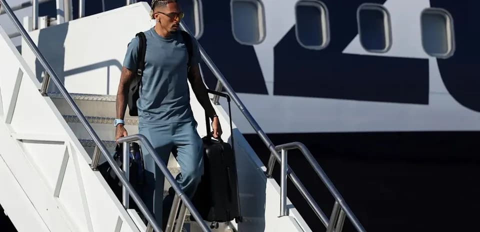 Jugador descendiendo de un avión con maleta