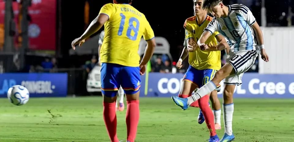 Jugador argentino disparando mientras dos rivales lo marcan