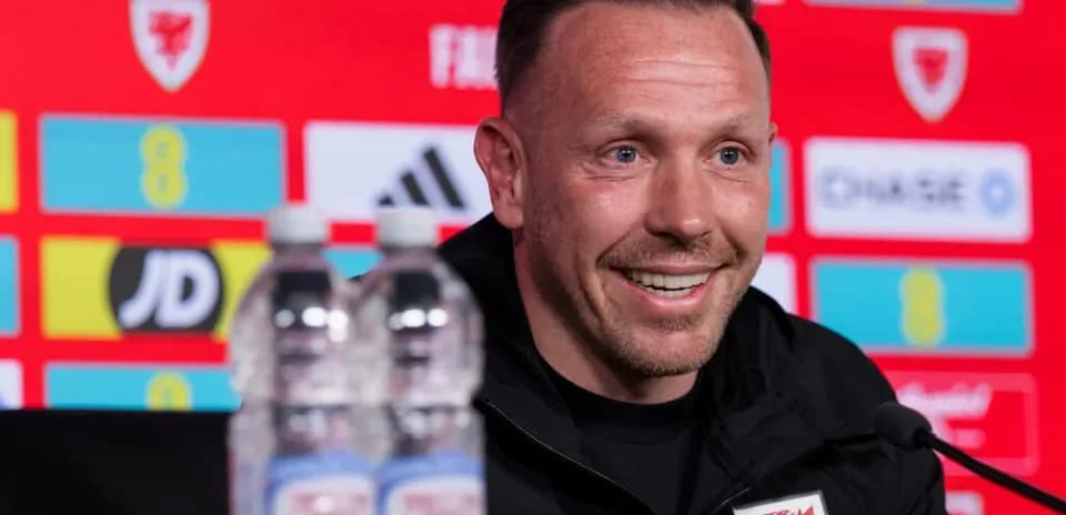 Entrenador en conferencia de prensa con sonriendo