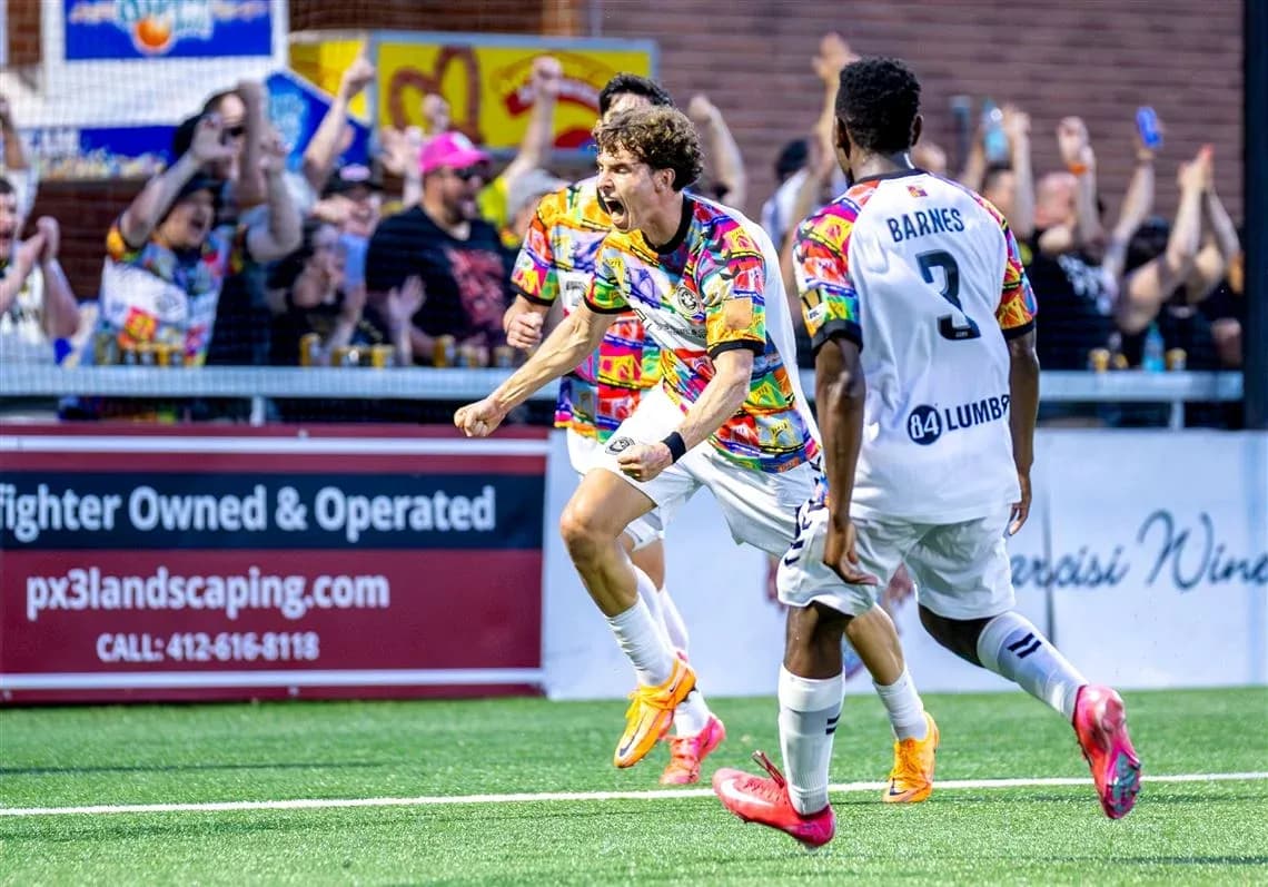 Jugador celebra un gol con aficionados detrás