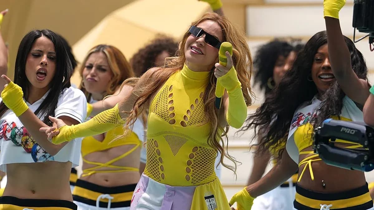 Artista actuando con bailarinas en vestuario colorido