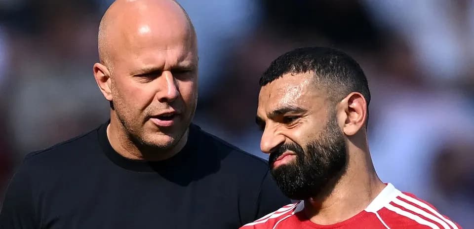 Dos hombres conversando en el campo de fútbol