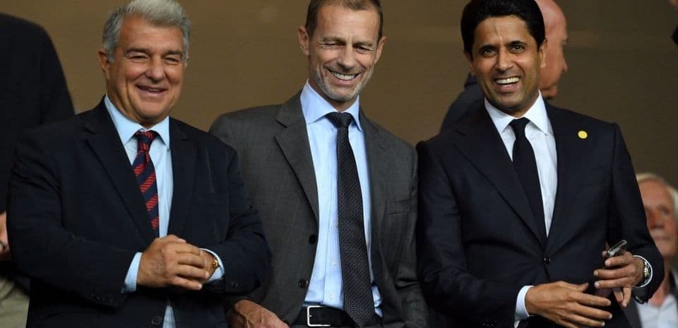 Tres ejecutivos sonriendo en un evento deportivo