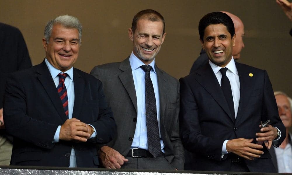Tres ejecutivos sonriendo en un evento deportivo