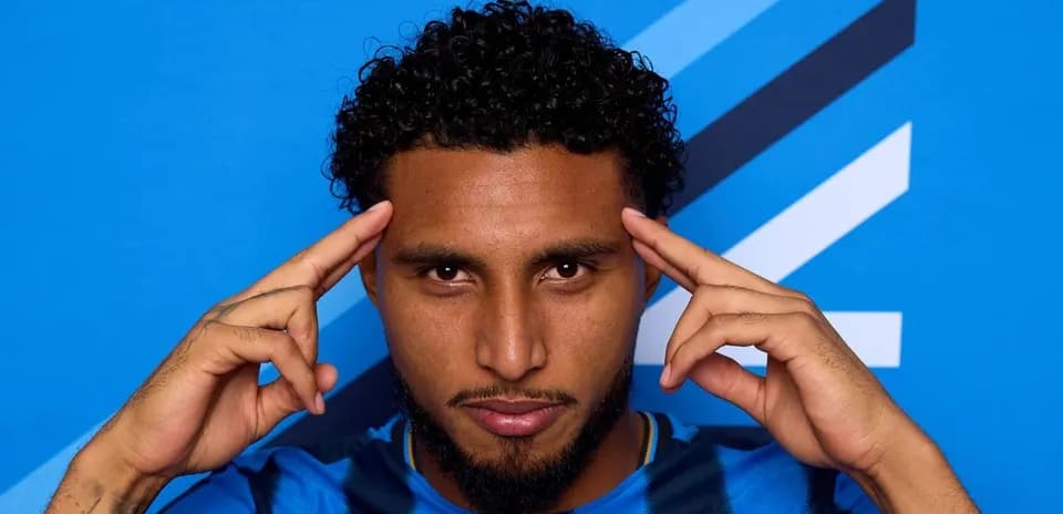 Jugador posando con fondo azul y camiseta de rayas