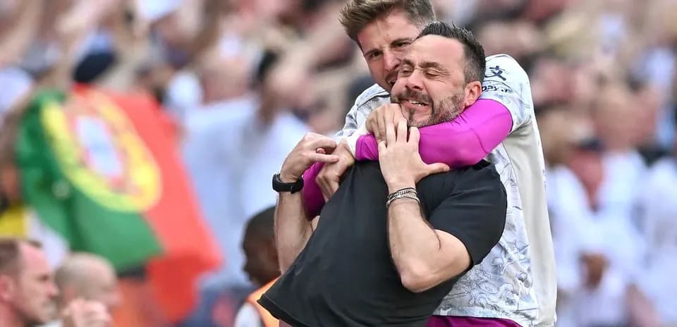 Dos entrenadores abrazándose en celebración