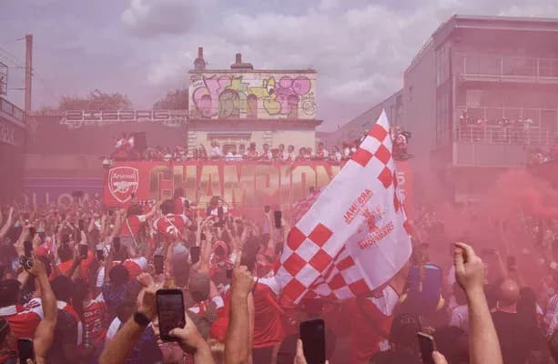 Aficionados de Arsenal celebrando con humo y banderas