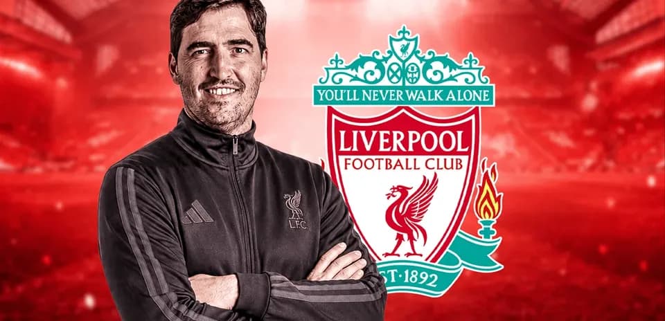 Entrenador de Liverpool posando con el logo del club