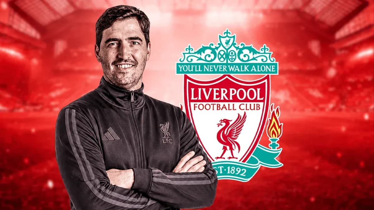 Entrenador de Liverpool posando con el logo del club
