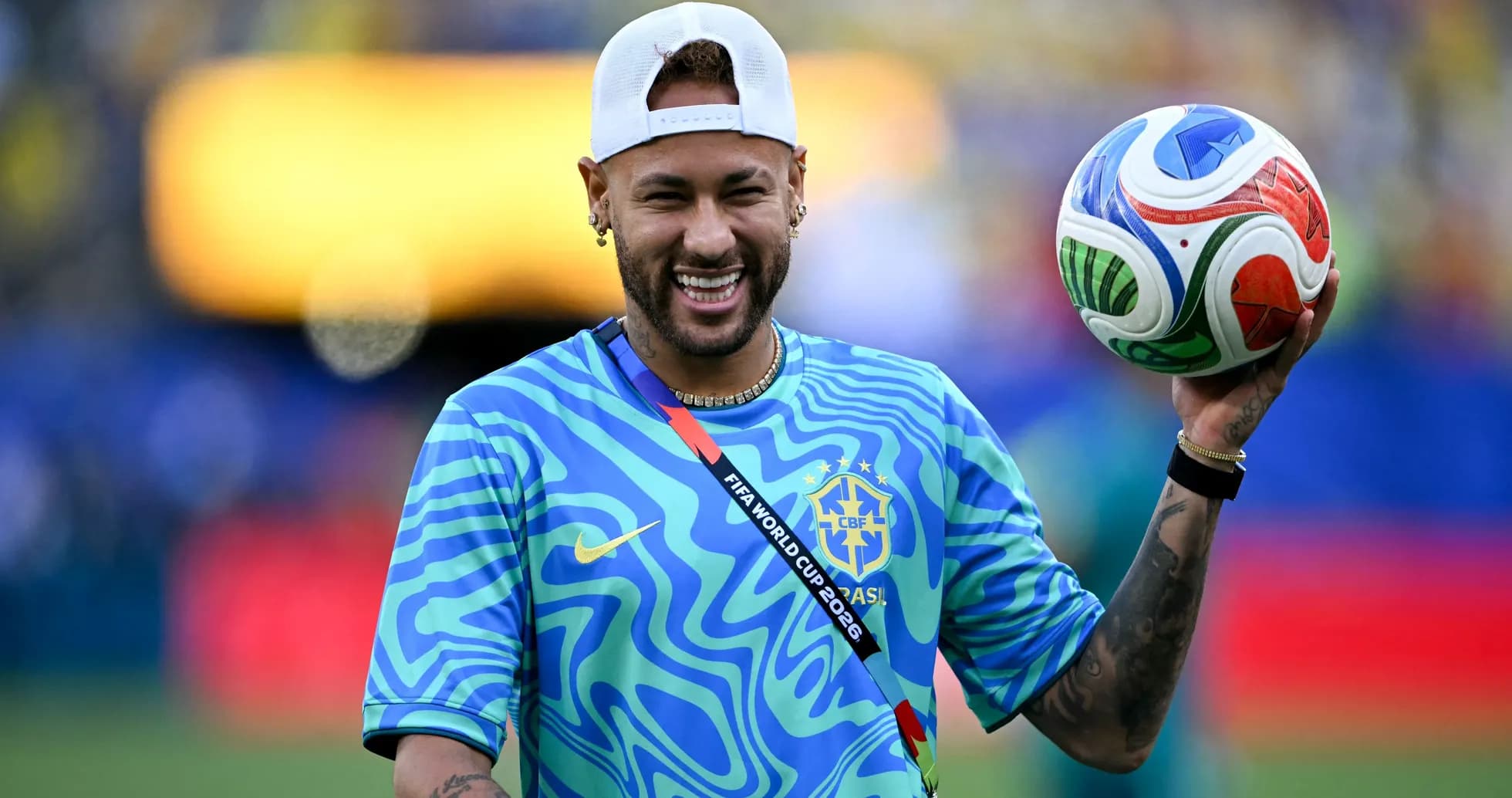 Neymar sosteniendo un balón de fútbol sonriente