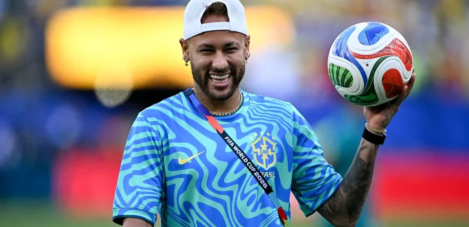 Neymar sosteniendo un balón de fútbol sonriente