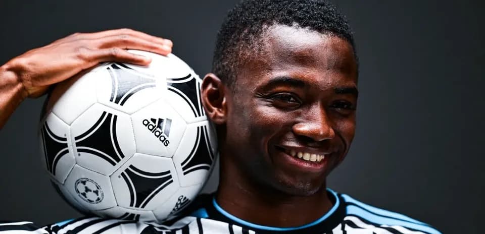 Jugador sosteniendo un balón de fútbol en su hombro