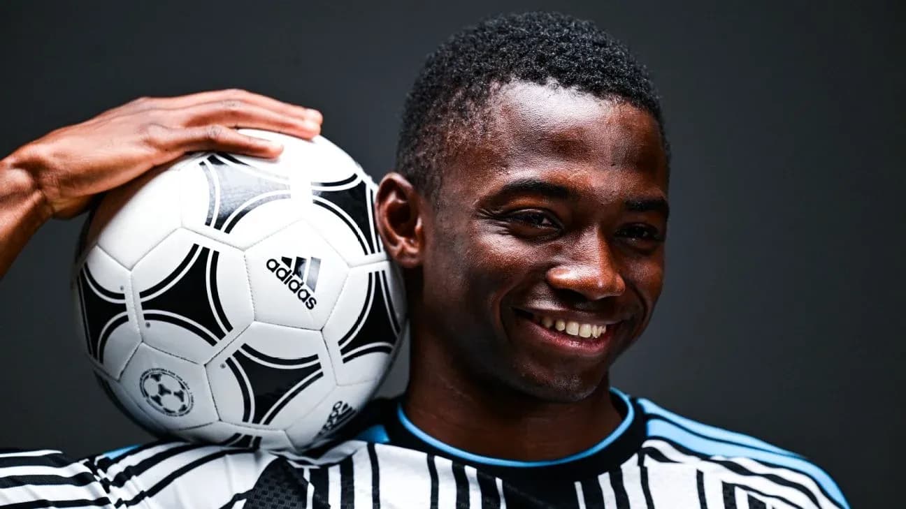 Jugador sosteniendo un balón de fútbol en su hombro