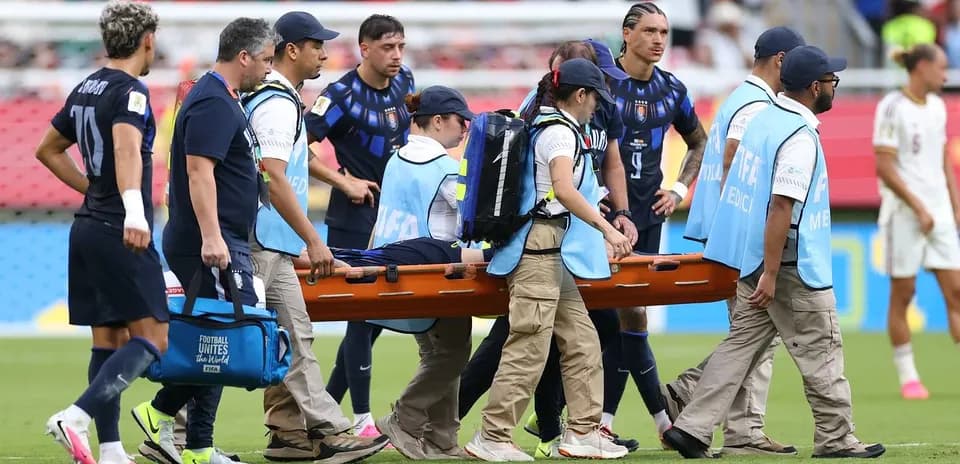 Equipo médico transportando a un jugador en camilla