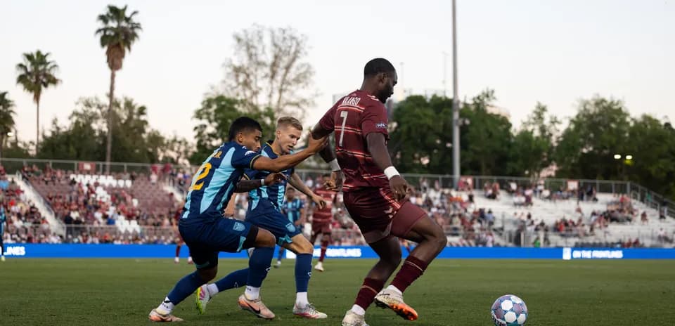 Dos jugadores persiguiendo el balón en el partido