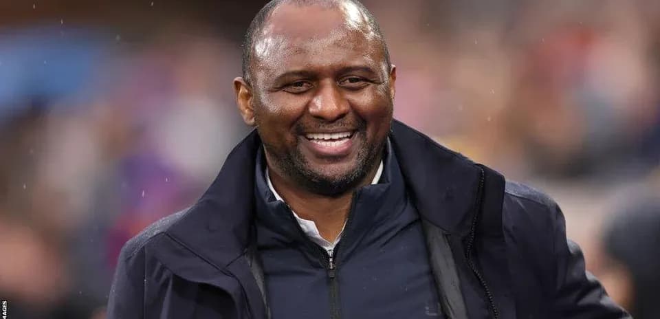 Entrenador sonriendo en el campo durante el partido