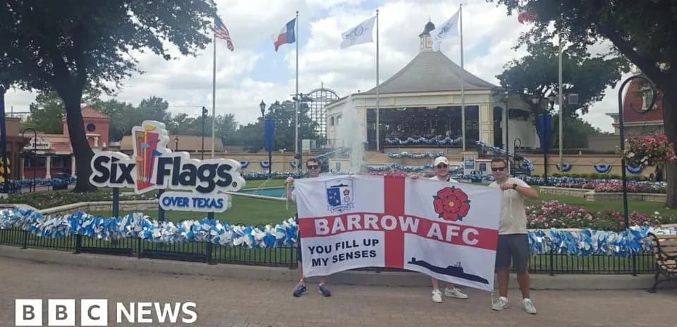 Dos aficionados sosteniendo una bandera en Six Flags
