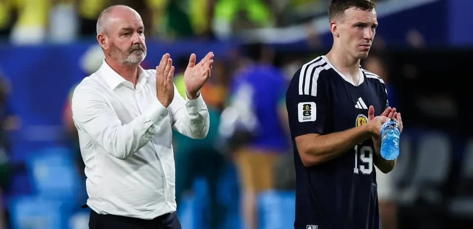 Entrenador aplaudiendo junto a jugador en campo