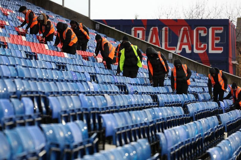 Personal limpiando asientos en el estadio Selhurst Park