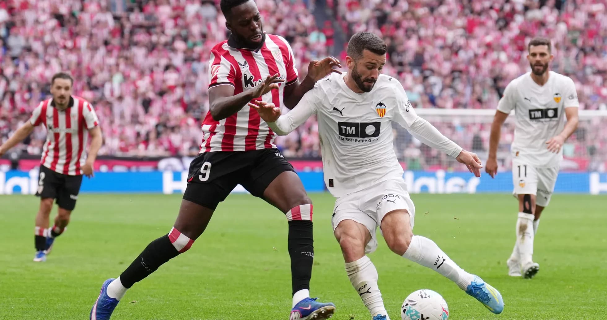 Jugador de Athletic Club disputa el balón con un jugador de Valencia