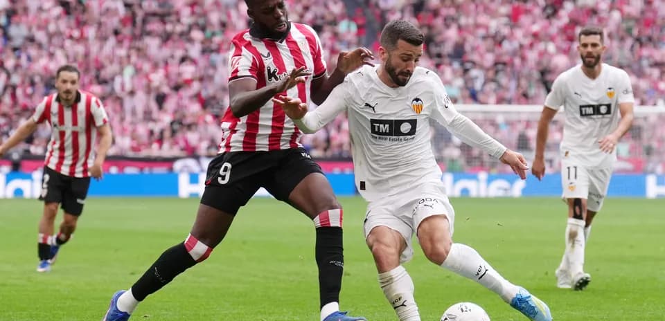 Jugador de Athletic Club disputa el balón con un jugador de Valencia