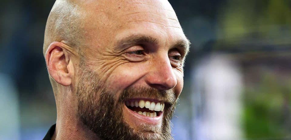 Hombre sonriente con barba en un evento deportivo