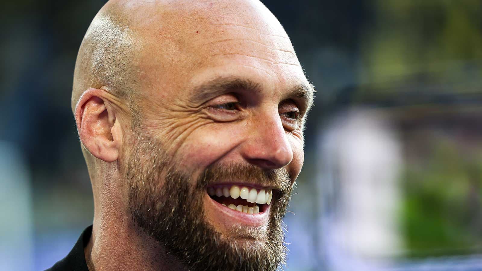 Hombre sonriente con barba en un evento deportivo