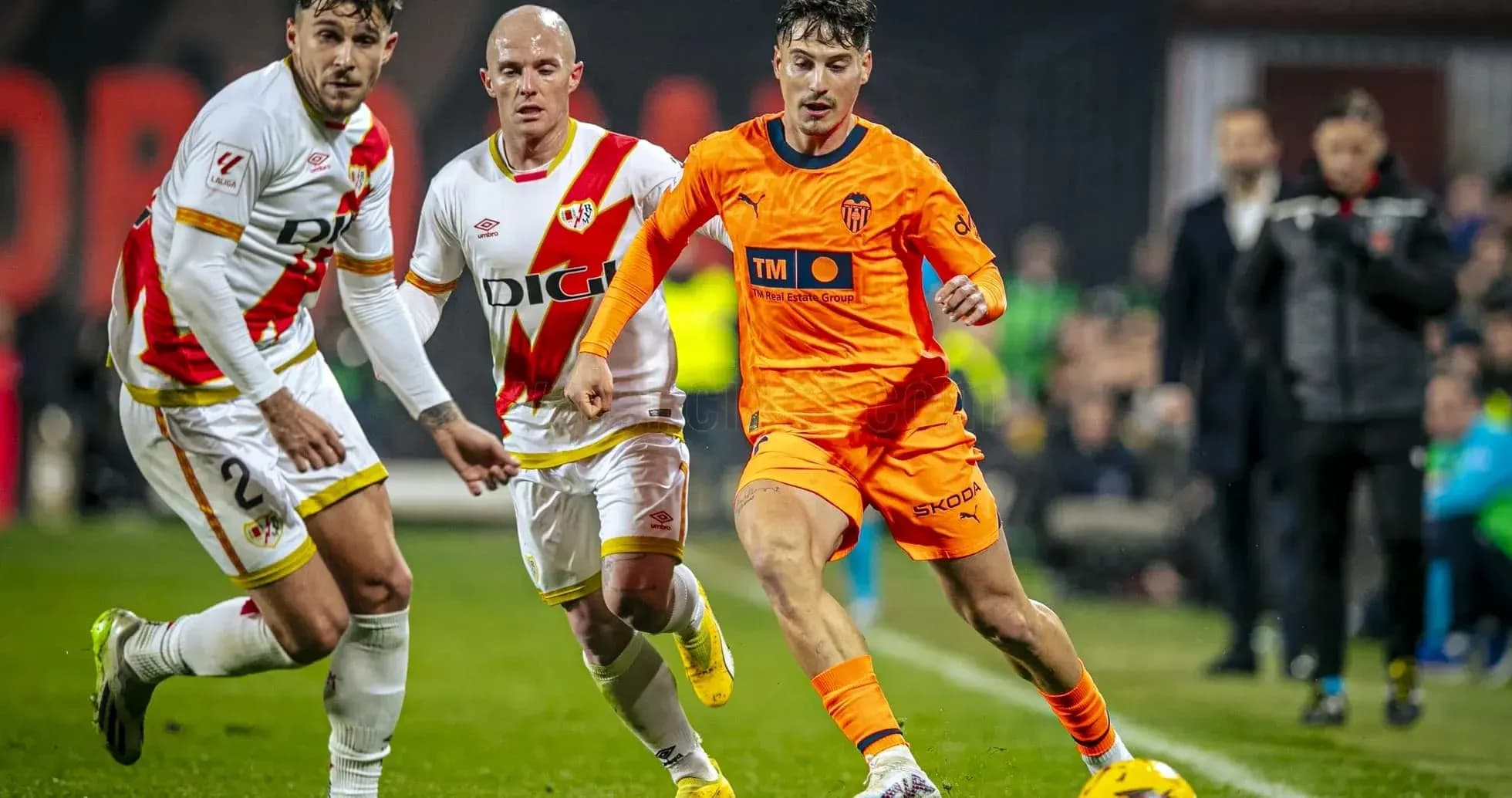 Jugador de Valencia driblando a rivales de Rayo Vallecano