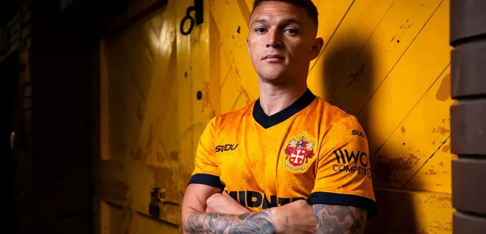 Jugador posando con camiseta naranja frente a puerta amarilla