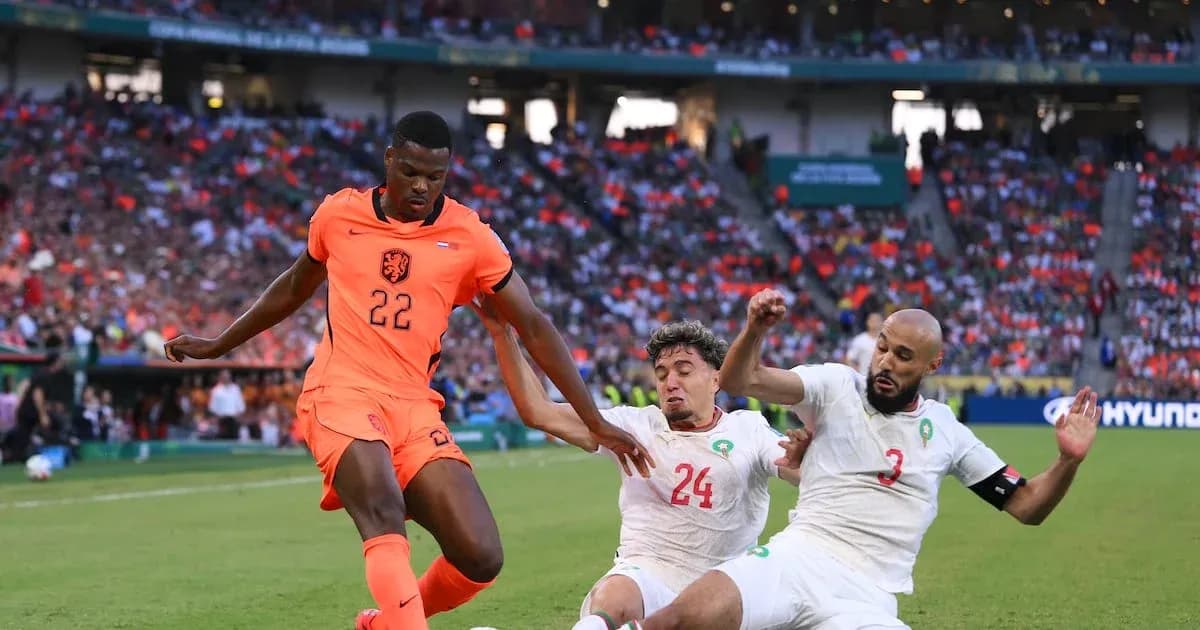 Jugador de Países Bajos driblando entre dos defensores rivales