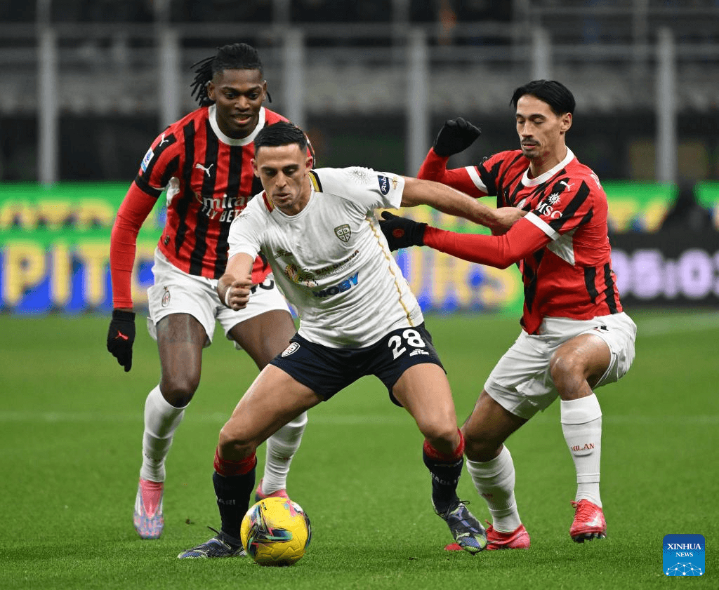 Jugador de Cagliari en acción contra jugadores del AC Milan