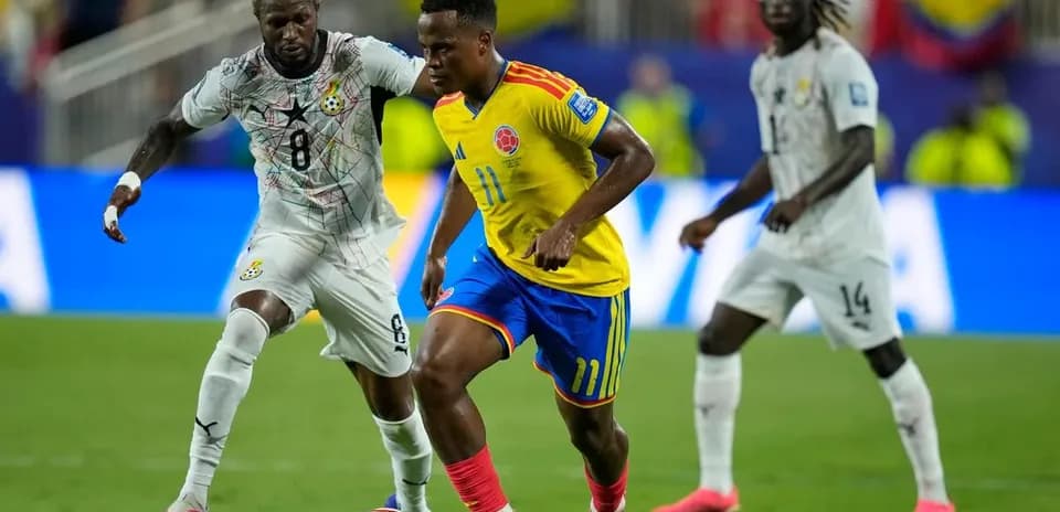 Jugador colombiano driblando a adversario ghanés en partido