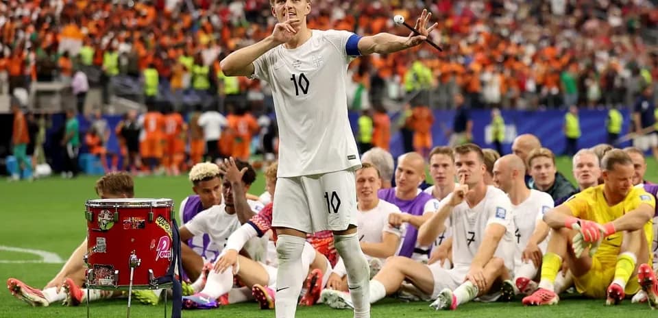 Jugador con camiseta blanca señalando a la afición