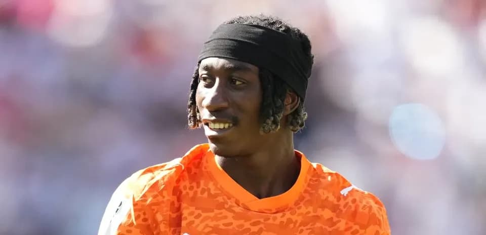 Portero de Costa de Marfil sonriendo en uniforme naranja