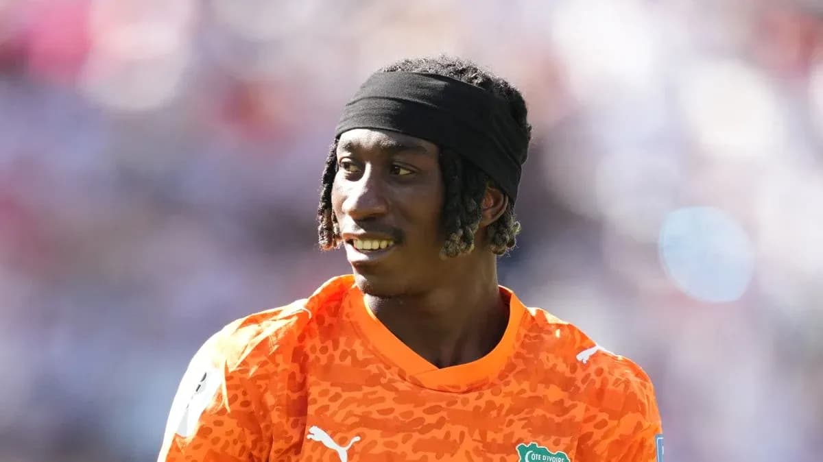 Portero de Costa de Marfil sonriendo en uniforme naranja