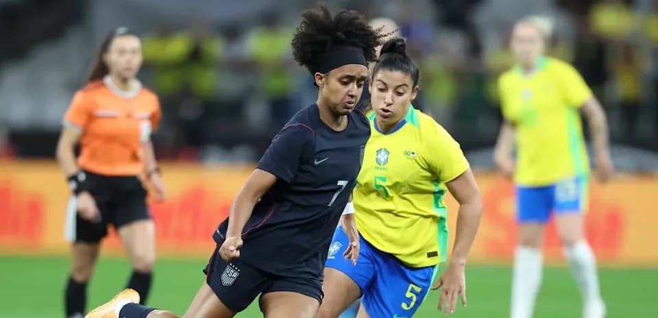 Jugadora de EE. UU. esquivando a rival de Brasil