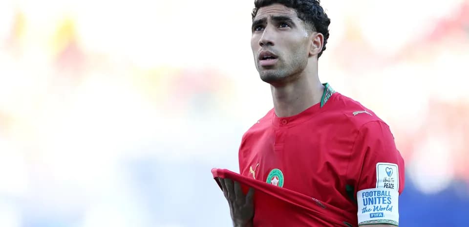 Jugador de Marruecos sosteniendo su camiseta en el campo