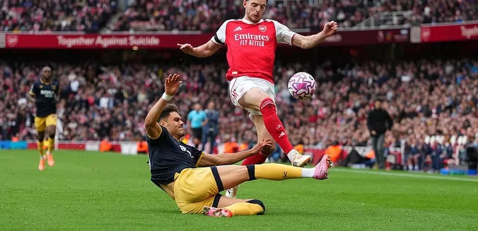 Jugador de Arsenal esquivando a oponente de West Ham