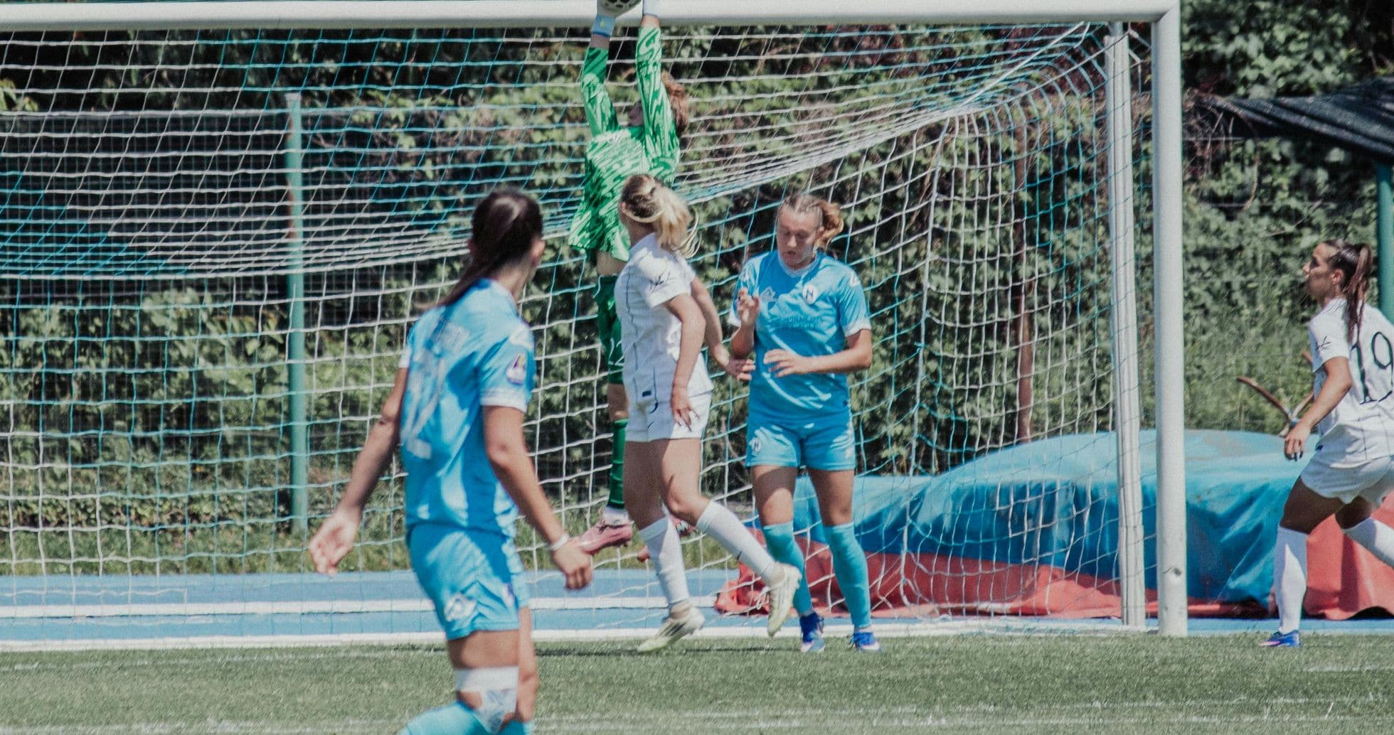 Portera atrapando el balón en el partido
