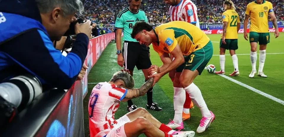 Jugador lesionado siendo asistido por oponente y árbitro