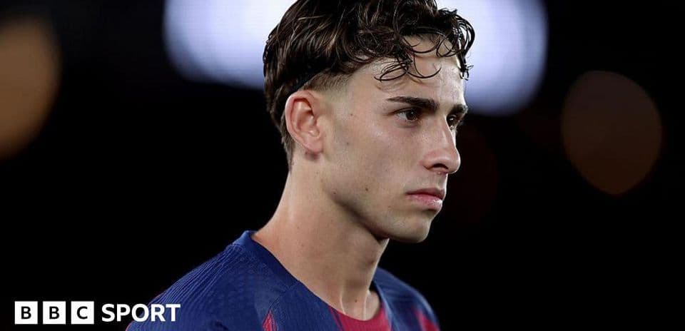 Jugador de fútbol en uniforme de Barcelona mirando hacia adelante