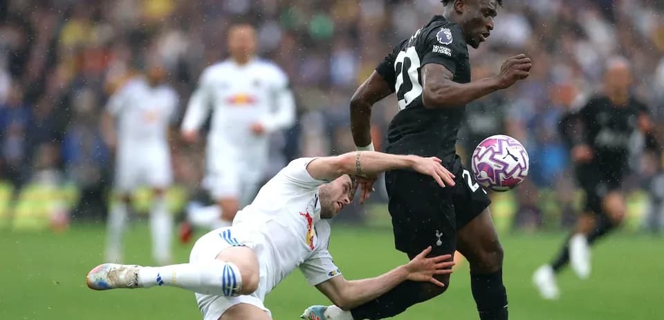 Jugador de Tottenham esquivando a rival en el suelo