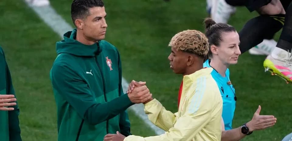 Cristiano Ronaldo y otro jugador saludándose en el campo