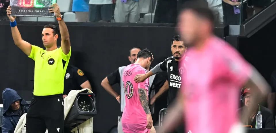 Jugador saliendo del campo con cartel de cambio